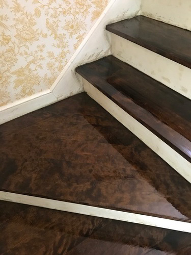 Freshly stained and finished hardwood staircase with odd angles and very dark stain.