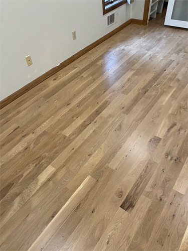 Recently stained and finished hardwood family room floor with light stain.